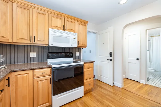 a view of a kitchen with wooden floor and electronic appliances