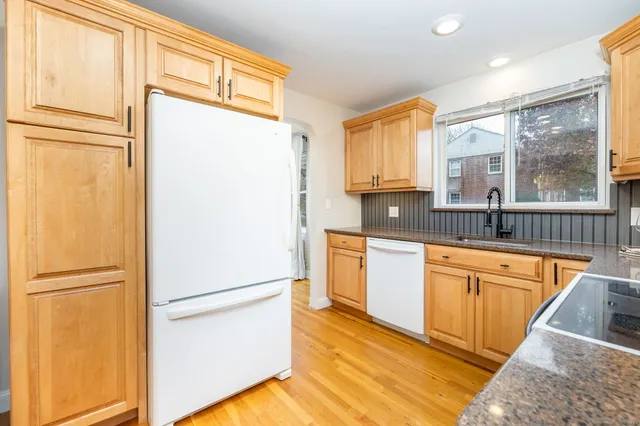 a kitchen with stainless steel appliances granite countertop a refrigerator a sink and a stove