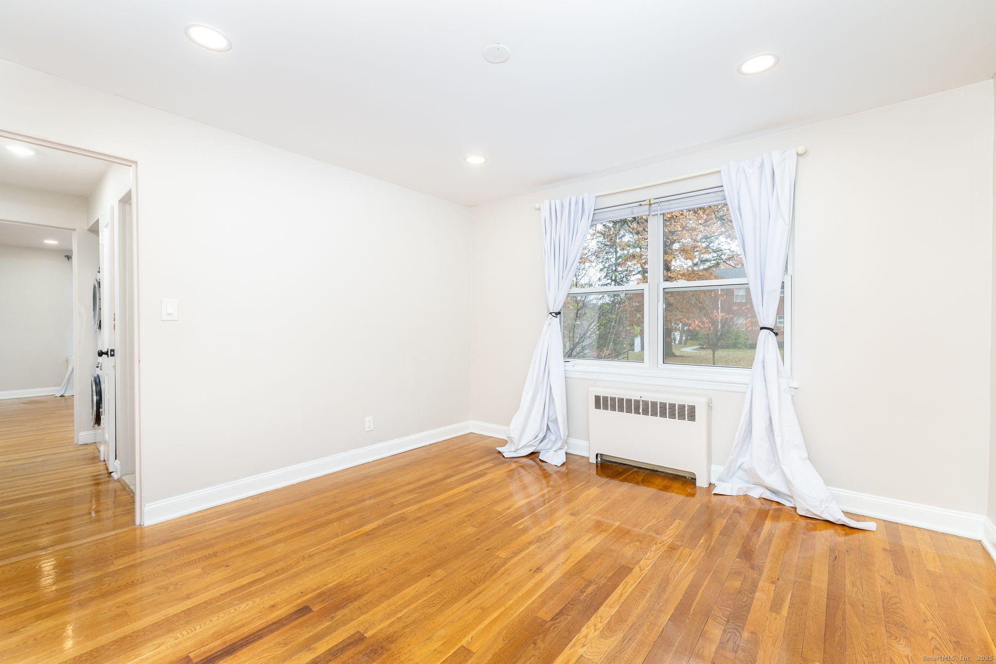 43 Arnold Way, Unit 43 West Hartford, CT 06119 - Photo 8 of 21 a view of an empty room with wooden floor and a window