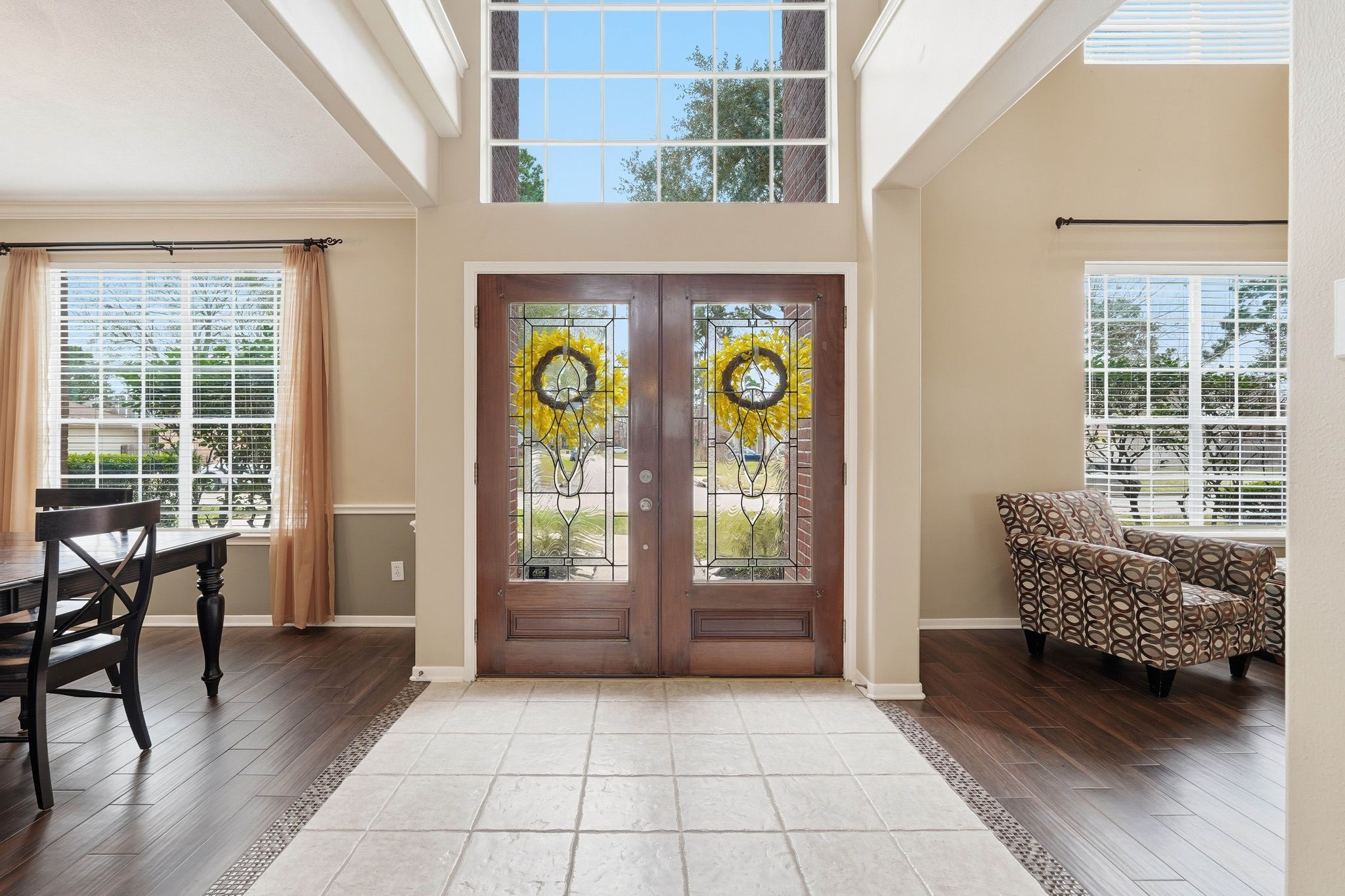 2515 Woodsboro Drive Spring, TX 77388 - Photo 3 of 44 This inviting entryway features a grand wooden door with decorative glass, high ceilings, and abundant natural light. The space includes elegant tile flooring and leads into a cozy living area with wood tile flooring.