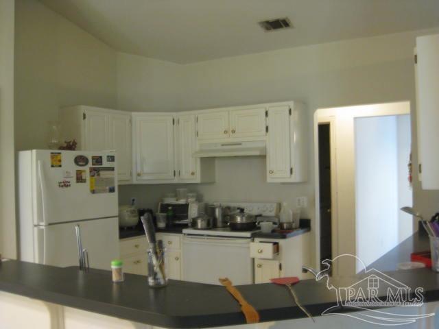 7259 Rampart Way Pensacola, FL 32505 - Photo 3 of 6 a kitchen with granite countertop a refrigerator and a stove top oven