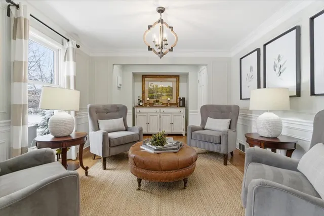 a living room with furniture a chandelier and a window