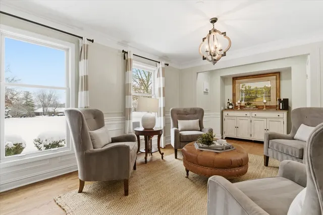 a living room with furniture chandelier and a large window