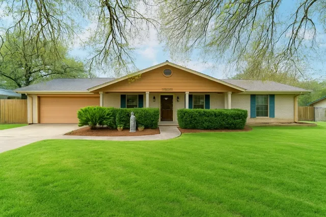 a front view of a house with a garden and yard