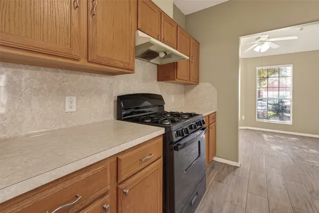 a kitchen with wooden cabinets and a stove top oven