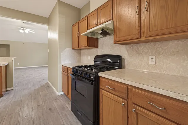 a kitchen with stainless steel appliances granite countertop a sink a stove a refrigerator and cabinets