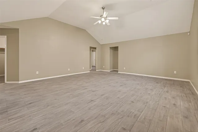 a view of an empty room with a chandelier fan