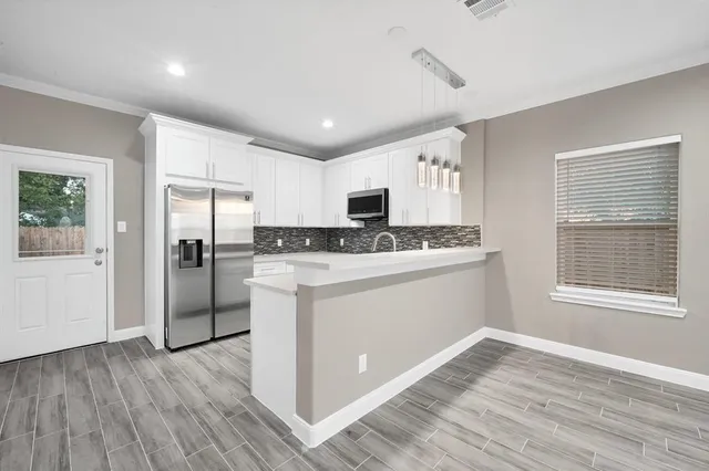 a kitchen with stainless steel appliances granite countertop a refrigerator and a stove top oven