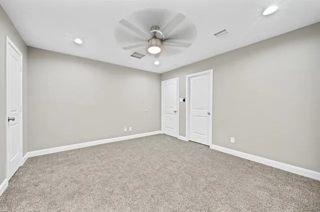 an empty room with a ceiling fan and a window