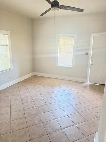 an empty room with windows and fan