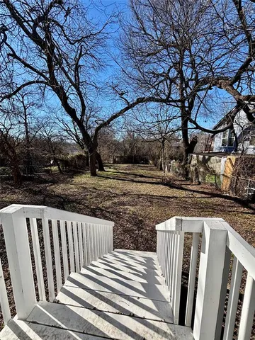 a view of a yard with wooden fence