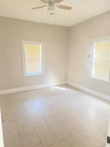 an empty room with a window and a fan