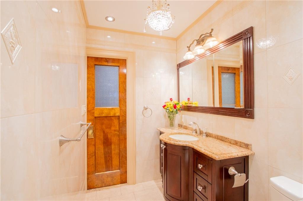 136 Bay Ridge Avenue Brooklyn, NY 11220 - Photo 29 of 48 a bathroom with a granite countertop sink a mirror and a shower