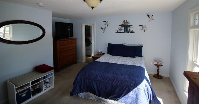 213 Monomoscoy Road Mashpee, MA 02649 - Photo 13 of 33 a bedroom with a bed and a chandelier