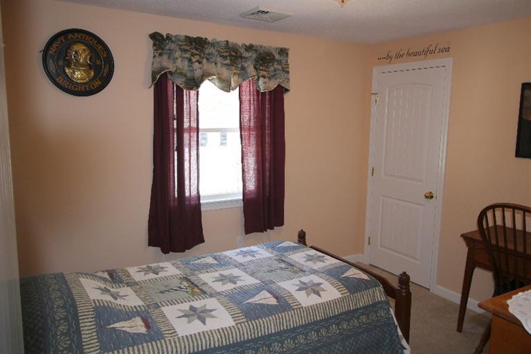 213 Monomoscoy Road Mashpee, MA 02649 - Photo 16 of 33 a bed sitting in a bedroom next to a window