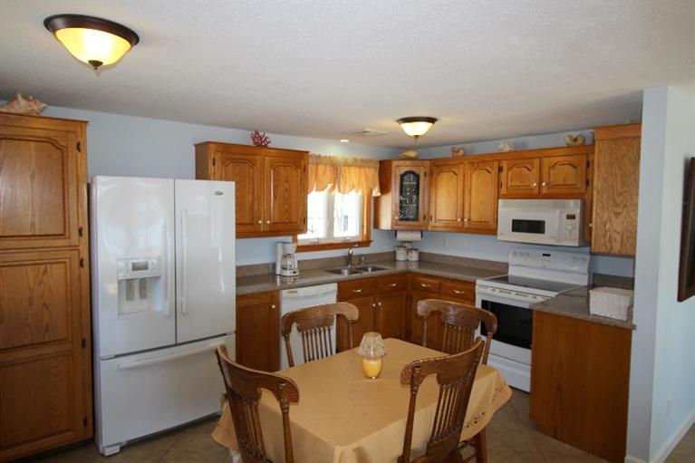 213 Monomoscoy Road Mashpee, MA 02649 - Photo 9 of 33 a kitchen with a refrigerator a stove a sink and a microwave