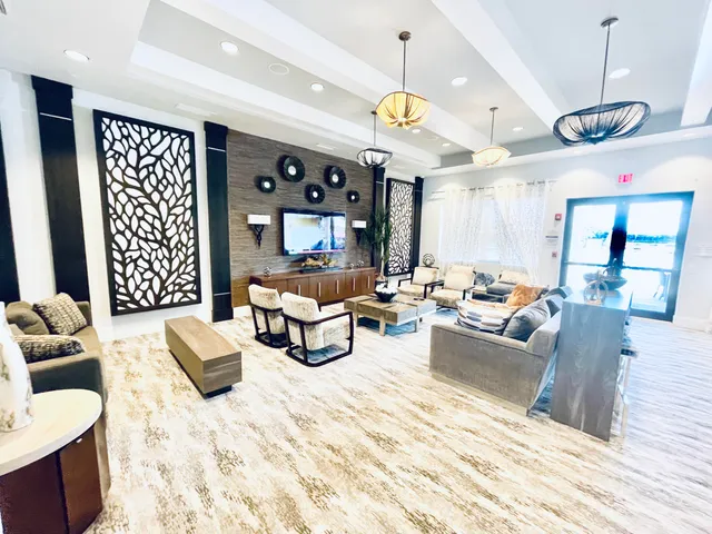 a living room with furniture kitchen view and a chandelier