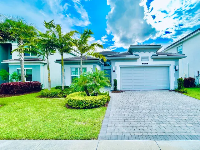 a front view of a house with a yard and garage