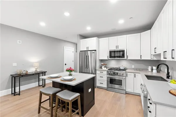 a kitchen with a stove a sink a dining table and chairs