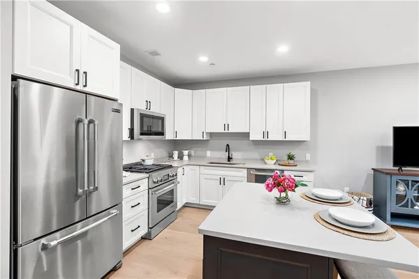 a kitchen with a sink stainless steel appliances and white cabinets