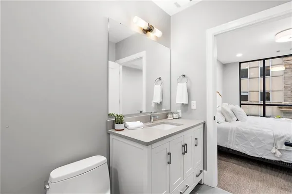 a en suite bathroom with a double vanity sink a mirror and a toilet