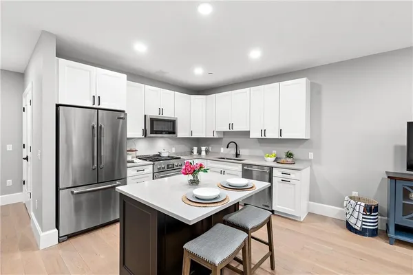 a kitchen with white cabinets stainless steel appliances and refrigerator