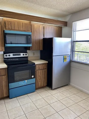 a kitchen with a refrigerator stove and cabinets