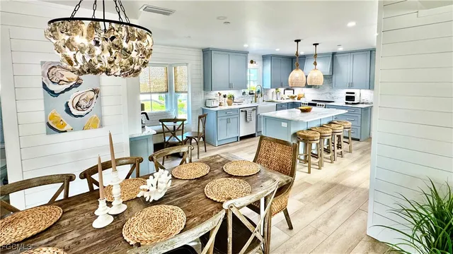 a open dining room with furniture and chandelier
