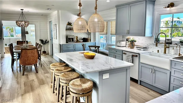 a kitchen with stainless steel appliances granite countertop a table chairs in it and wooden floors