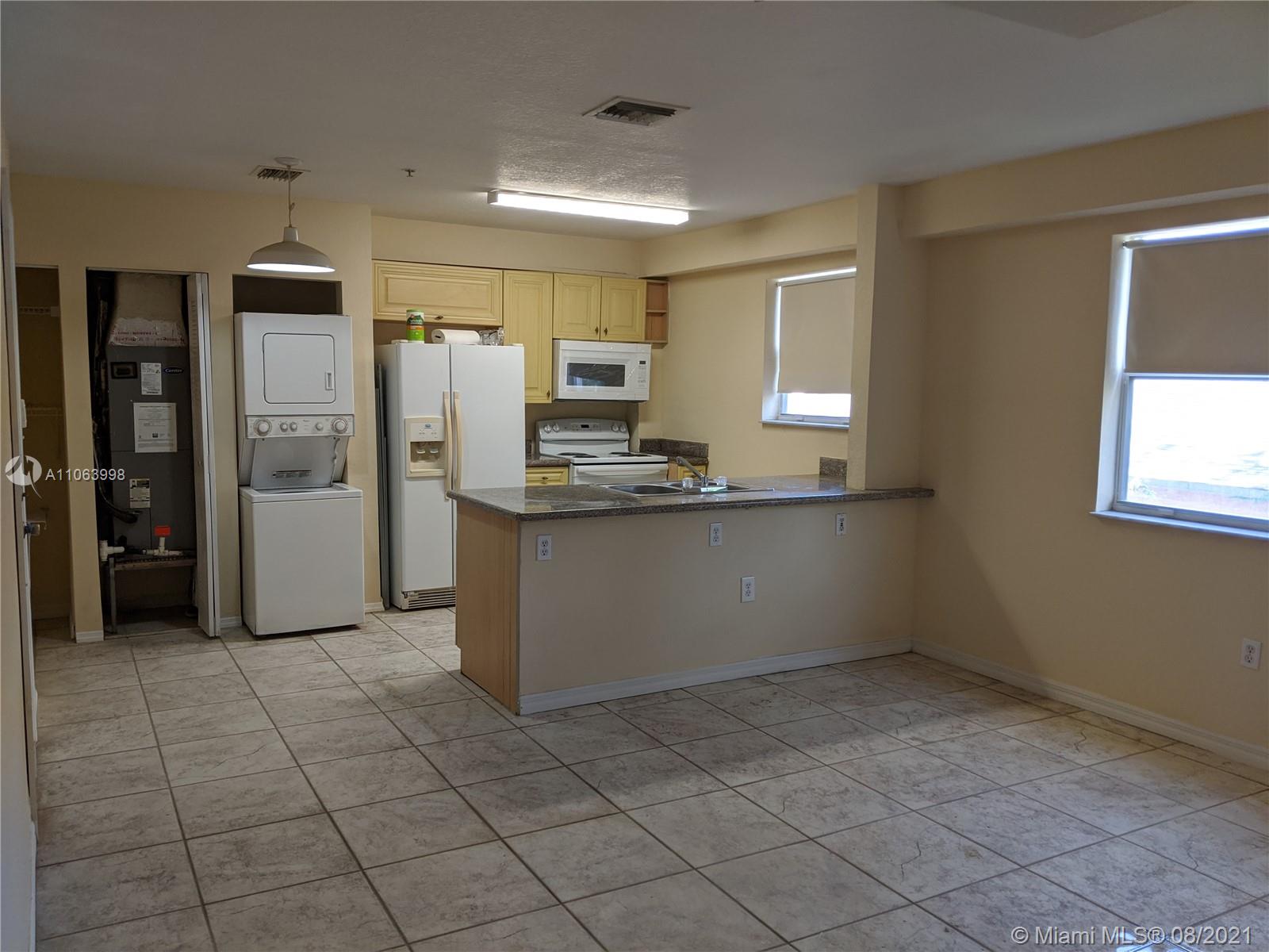 520 Southwest 5th Street, Unit 203 Miami, FL 33130 - Photo 5 of 51 a kitchen with stainless steel appliances kitchen island granite countertop a refrigerator and a sink