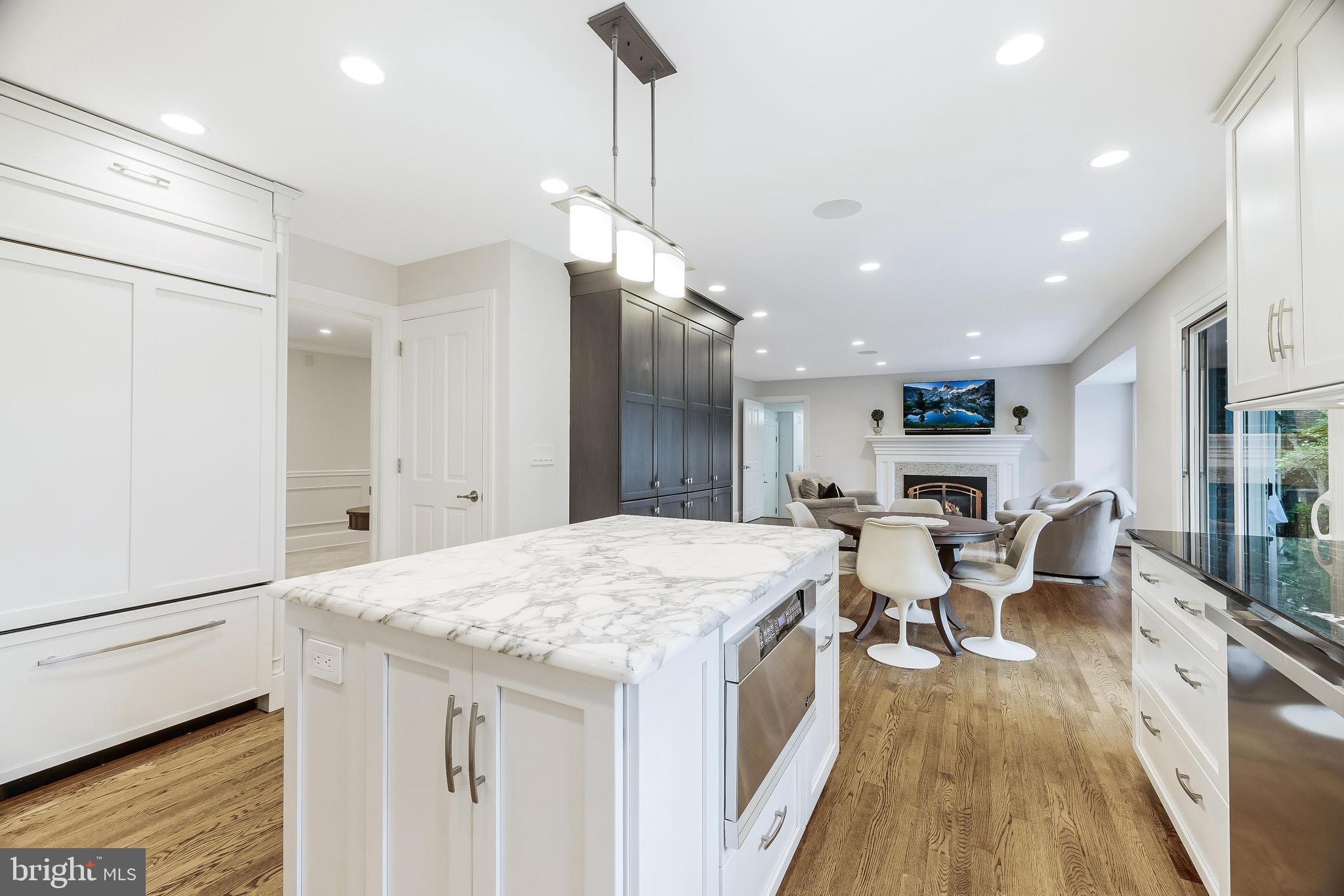 1205 Suffield Drive McLean, VA 22101 - Photo 20 of 76 a large kitchen with kitchen island a island a stove a wooden floor and a dining table