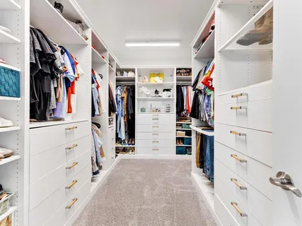 a view of walk in closet with clothes and shoes