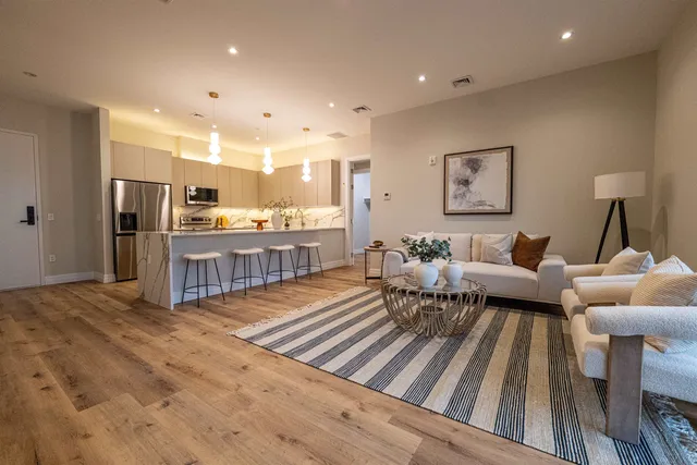 a living room with furniture and kitchen view