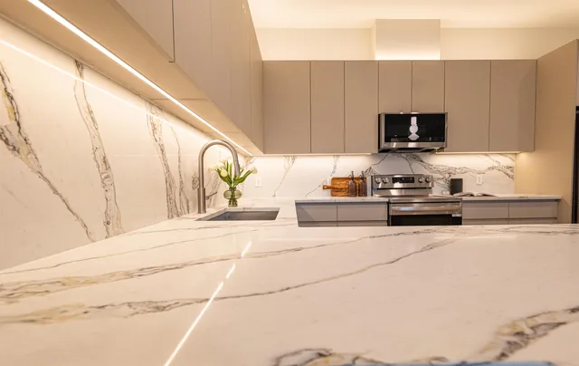 a kitchen with stainless steel appliances kitchen island granite countertop a sink a stove and a microwave