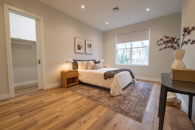 a bedroom with a bed lamp and a window