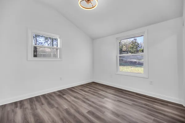 a view of a room with wooden floor and a toilet