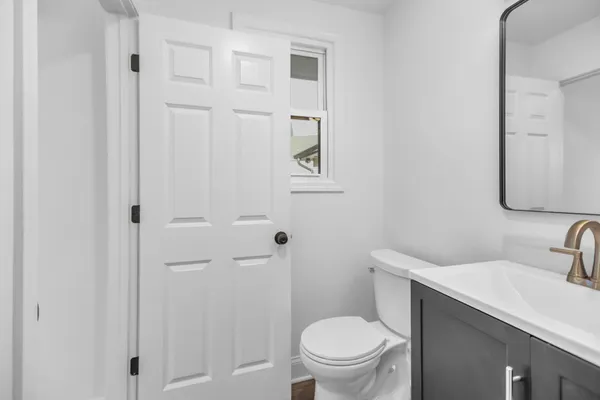 an empty room with wooden floor closet and windows