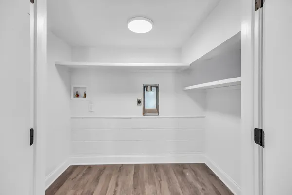 a view of a hallway with wooden floor and entryway