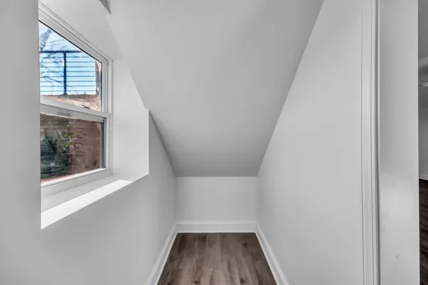a view of empty room with wooden floor and window