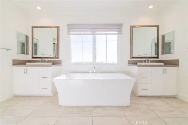 a white bath tub sitting in a bathroom and mirror