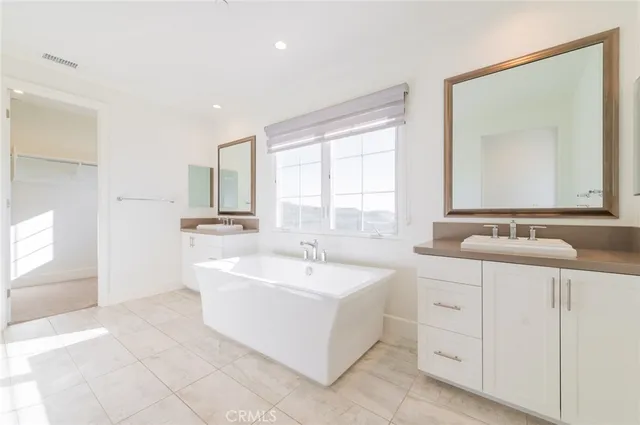 a bathroom with a sink mirror and a bathtub