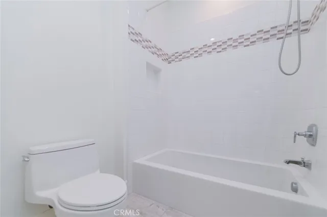 a white toilet sitting next to a bath tub and shower