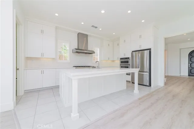a kitchen with white cabinets and stainless steel appliances