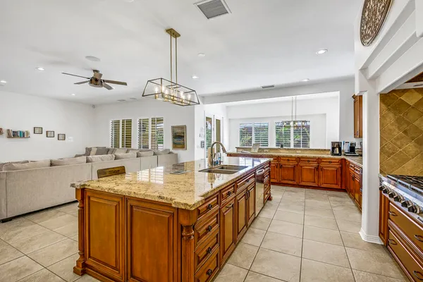 a kitchen with stainless steel appliances granite countertop a sink and a refrigerator