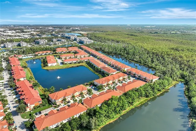 an aerial view of residential houses with outdoor space and ocean view