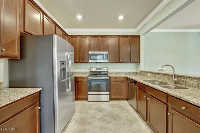 a kitchen with stainless steel appliances granite countertop a refrigerator stove and oven
