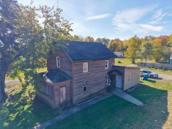 a view of a house with a yard and wooden fence