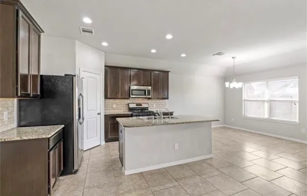a kitchen with stainless steel appliances granite countertop a sink stove and refrigerator
