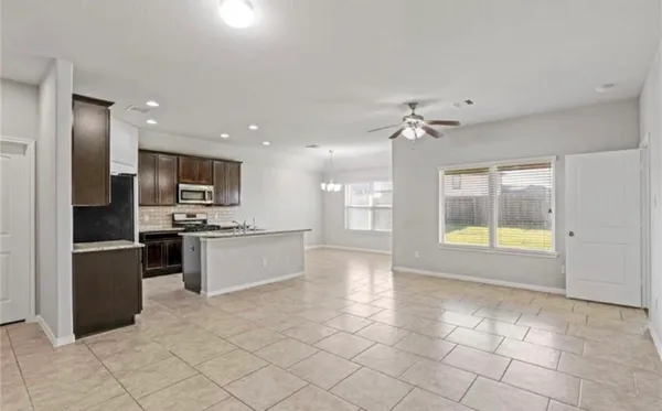 a large kitchen with stainless steel appliances granite countertop a stove and a refrigerator