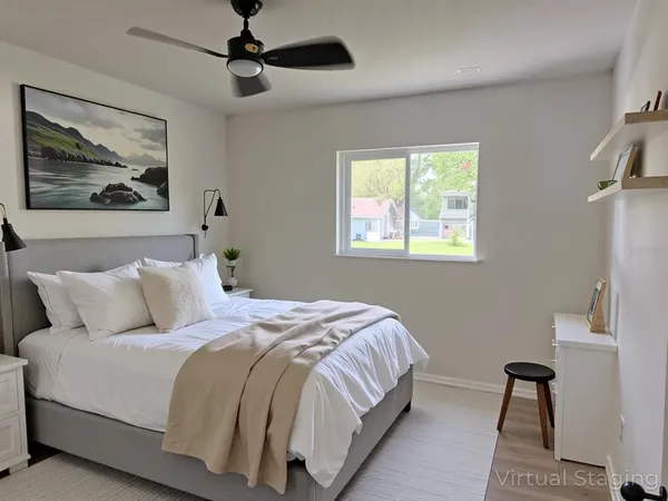 a bedroom with a bed and a painting on the wall